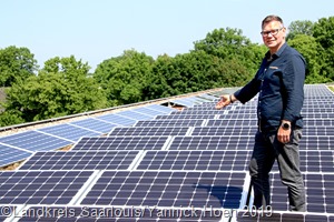 Klimaschutzmanager Ralf Rupp zeigt die Photovoltaikanlage auf dem Schuldach des KBBZ in Saarlouis. 