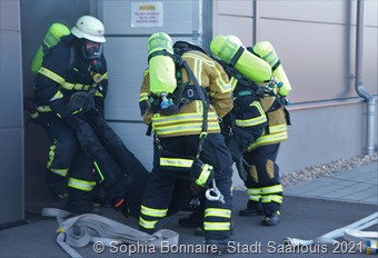Einige Feuerwehrleute bei der Rettung einer Person aus der Halle. (Fotos: Sophia Bonnaire)_9893