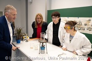 Zum großen Tag gab es Show-Experimente in den neuen naturwissenschaftlichen Räumen der Schule. Unter anderem wurde gezeigt, wie sich eine Kupfermünze vergolden lässt. Von links: Landrat Patrik Lauer, Bildungsministerin Christine Streichert-Clivot, Mikael Johannes und Tamara Petry (beide aus der 12. Klasse) 6706_klein